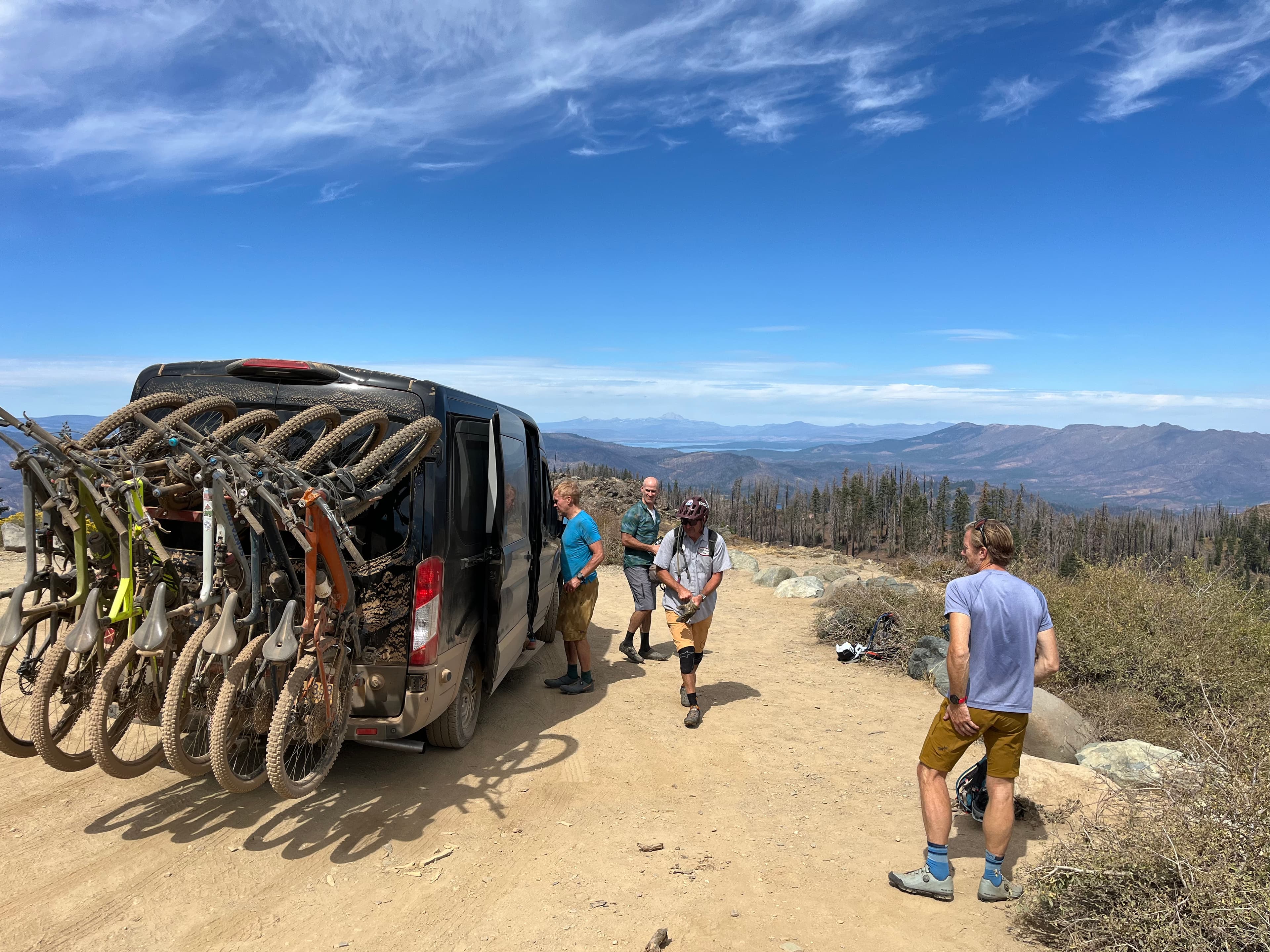 Van loaded with mountain bikes at a mountaintop with panoramic views